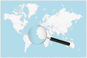 Magnifying glass showing a map of Guinea-Bissau on a world map. vector