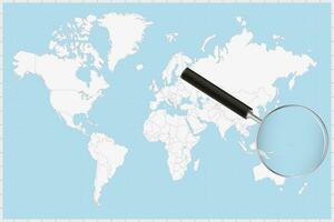 Magnifying glass showing a map of Nauru on a world map. vector