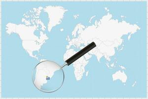 Magnifying glass showing a map of Uruguay on a world map. vector