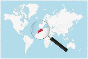 Magnifying glass showing a map of Morocco on a world map. vector