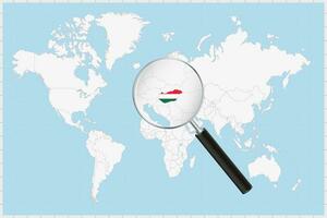 Magnifying glass showing a map of Hungary on a world map. vector