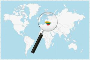 Magnifying glass showing a map of Lithuania on a world map. vector