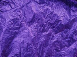 Purple texture of wrinkled plastic or crumpled plastic of reflecting. Grungy copy space photo