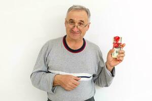 Smiling senior gentleman holding money, isolated on white background photo