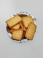 Wheat biscuits in the steel plate with white background. Indian biscuits popularly known as Chai biscuit in India photo