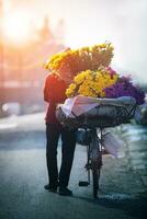 doméstico vida fotografía de vietnamita mujer y de venta flor bicicleta en Hanoi ciudad foto