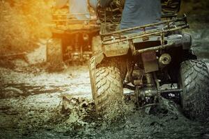 action shot of sport atv vehicle running in mud track photo