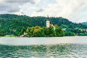 Ancient church in the middle of the lake surrounded by colourful trees photo