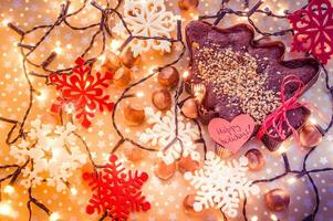 pan de jengibre árbol rodeado con Navidad luces y rojo y blanco copos de nieve y contento Días festivos pegatina foto