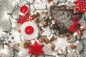 pan de jengibre árbol rodeado con Navidad luces y rojo y blanco copos de nieve foto