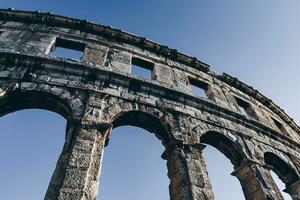 antiguo romano anfiteatro con azul cielo en el antecedentes foto