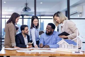 Team of architecture and engineers are discussing and brainstorming on floor plan over clean energy and power saving house design using solar panel for green industry and futuristic home development photo