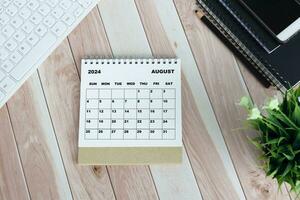 White August 2024 calendar on office wooden desk. photo