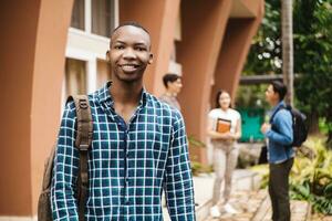 Portrait of black young man student with college over background. photo