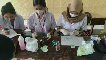 Surabaya, Indonesia, Oct 09, 2023 - Three Indonesian female doctors take notes, check medical equipment and communicate with patients at the hospital. Medicine, healthcare and people concept. video