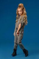 Little girl with a long curly hair in a fashionable clothes photo