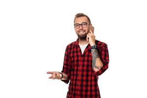 Portrait of a casual young man speaking on the phone and smiling while looking away, somewhere up. Studio shot on white background photo