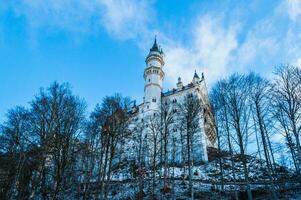 View from the bottom on the medieval castle with cloudy blue sky on the background photo