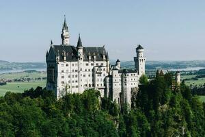 Famous fairytale Neuschwanstein castle on top of the mountain in Bavarian Alps in Germany photo