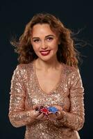 Casino concept. Portrait of young pretty caucasian woman, playing in casino. Roulette, poker chips, cards, wheel, black background photo