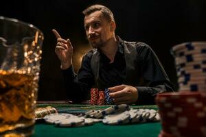 Man is playing poker with a cigar and a whiskey. A man winning all the chips on the table with thick cigarette smoke. photo