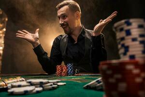 Man is playing poker. A man winning all the chips on the table with thick cigarette smoke. The concept of victory photo