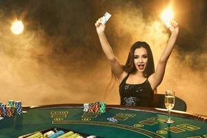 Gorgeous young woman sitting at poker table with glass of champagne photo