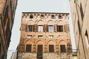 Beautiful colored and medieval street in the old town of Siena, Italy photo