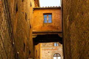 hermosa de colores y medieval calle en el antiguo pueblo de siena, Italia foto