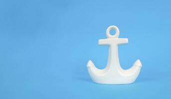 White anchor on a blue background. Copy space. Vacation concept. photo