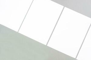 vacío blanco rectángulo póster maquetas acostado diagonalmente en un gris antecedentes foto