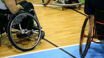 Basketball player in wheelchair with tattooed shoulder watching the game video