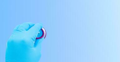 Hand in gloves with a stethoscope on a blue background. Medical background. photo