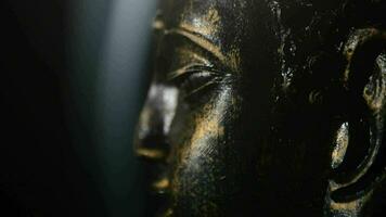 Buddha face, figure buddhist, rotating at black background with smoke video