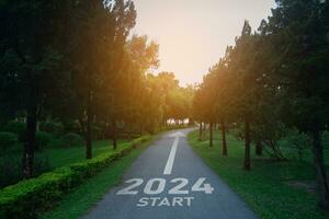 Happy new year 2024,2024 symbolizes the start of the new year. The letter start new year 2024 on the road in the nature route roadway have tree environment ecology or greenery wallpaper concept. photo