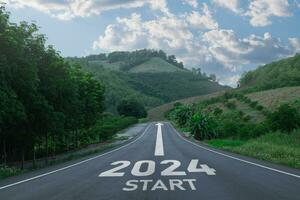Happy new year 2024,2024 symbolizes the start of the new year. The letter start new year 2024 on the road in the nature route roadway have tree environment ecology or greenery wallpaper concept. photo