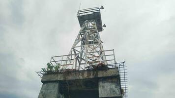 light tower in the middle of the sea with a sky background photo