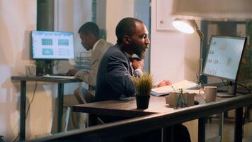 Manager checking online paperwork is in order during nightshift. Management executive looking over every office computer to verify employees managed to finish project tasks in time photo