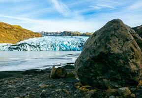 Big vatnajokull glacier cap in iceland next to frozen water in polar landscape, massive diamond shaped ice blocks in cold winter nature. Scandinavian arctic iceberg lagoon and icy rocks. photo