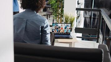 Employee attends videocall meeting with executive board and company CEO, discussing about new management strategy in office. Young man using online videoconference call on laptop. photo