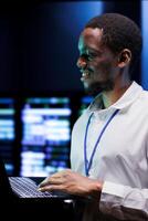 Happy supervisor monitoring server racks providing vast computing resources and storage. Data center enabling artificial intelligence to process massive datasets for machine learning training photo