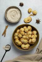 Puff pastry eyelet, Palmier cookies in a bowl with cinnamon and sugar on the light concrete background. Top view. photo