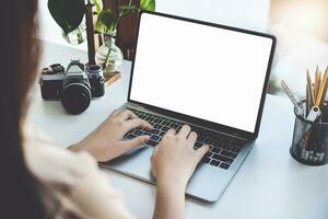 joven mujer utilizando trabajo desde hogar computadora a evitar el riesgo de contratación coronavirus en el empresa a trabajar, el blanco espacio en el computadora pantalla lata insertar texto. foto