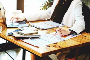 Investment concepts, businesswomen use document and computers to analyze stock markets, quantitative data collection, financial statement analysis, profitability through internet technology. photo