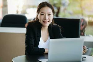 A female worker smiling happily while using a computer in the office. photo