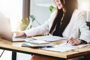 Investment concepts, businesswomen use document and computers to analyze stock markets, quantitative data collection, financial statement analysis, profitability through internet technology. photo