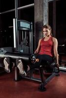 Woman exercising with crossover in fitness club or gym training legs photo