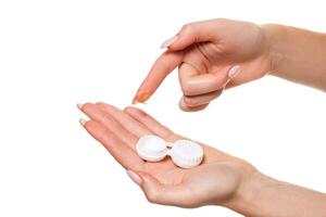 Contact eye lens. Close-up of woman hands holding white eyelense container. photo