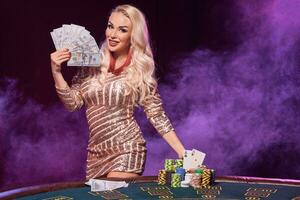 rubia mujer con un Perfecto peinado y brillante maquillaje es posando con jugando tarjetas en su manos. casino, póker. foto