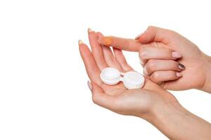 Contact eye lens. Close-up of woman hands holding white eyelense container. photo